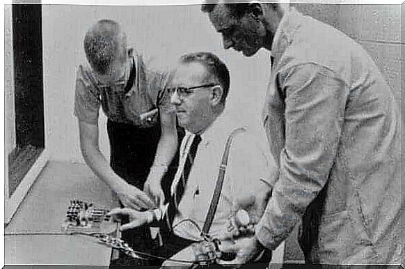 Men putting gadgets in another in Milgram's experiment