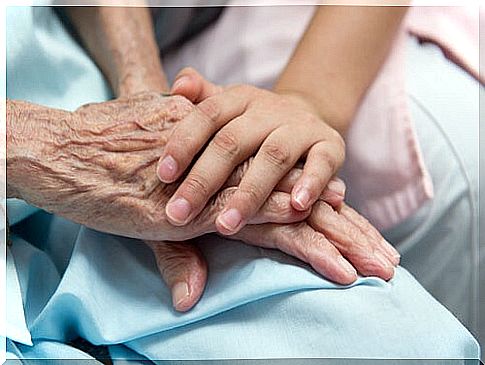 Hands of an elderly person with a healthcare professional