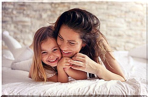 Mother with her daughter on top of the bed