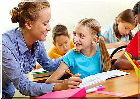 Teacher helping her student in class with homework