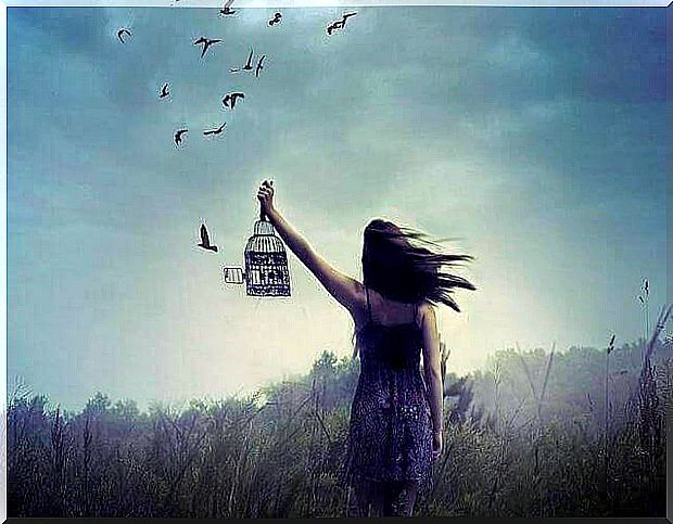 Woman releasing birds that represent the action of forgiving