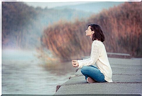 Woman doing mindfulness near a lake