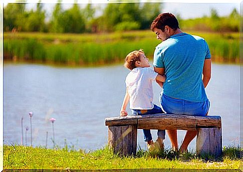 Father talking to his son sitting on a bench